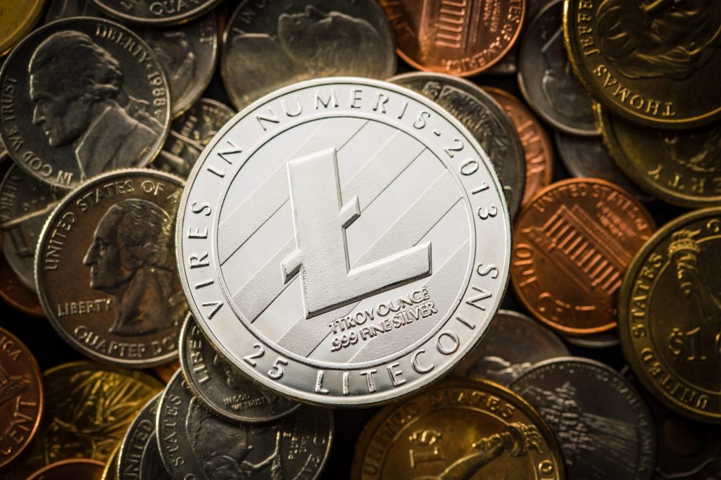 An extreme close-up shot reveals a Litecoin cryptocurrency round among various US coins.